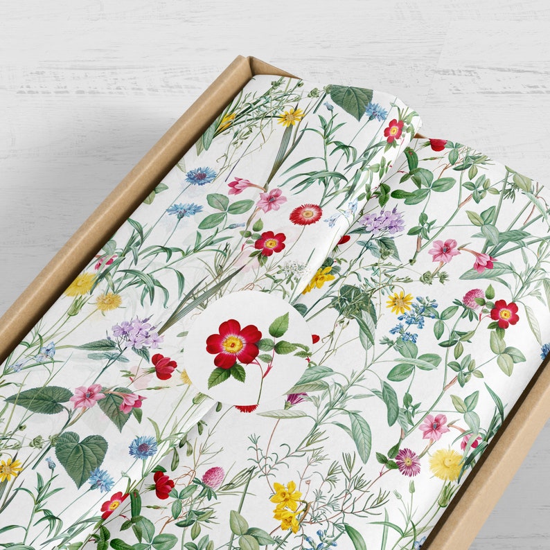 A parcel wrapped in wild flower tissue paper with a flower sticker