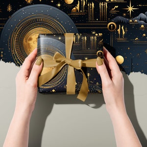 Moon phase and Zodiac Gift Wrapping Paper around a parcel with a Gold Ribbon held in two hands