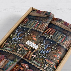 May include: Tissue paper with a fantasy bookshelf design, complete with books, mushrooms, and flowers. The paper is presented in a cardboard box. The text on the paper reads "TEMPERCH TISSUE PAPER".