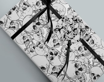 May include: White wrapping paper with a black and white skull pattern. The paper is wrapped around a gift box with a black ribbon.