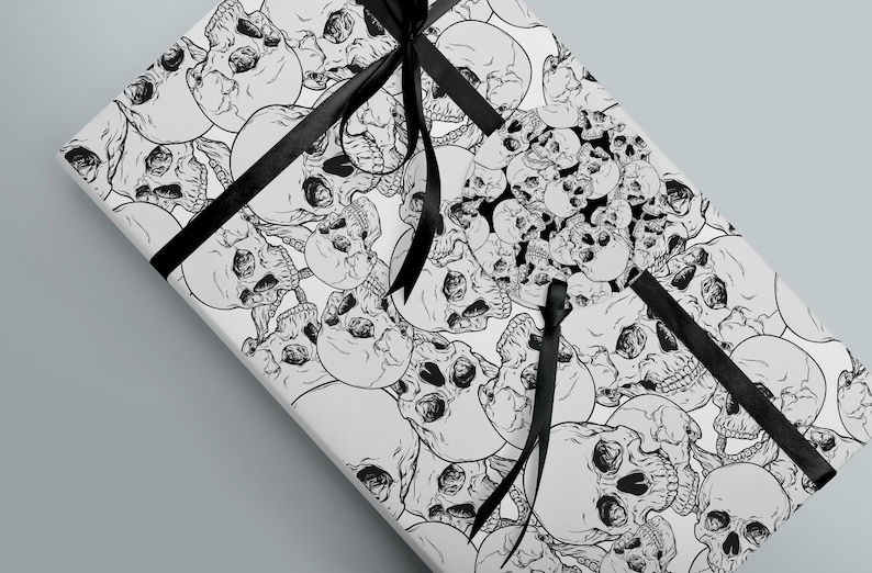 Wrapping paper featuring skulls shown wrapping a gift with gift tag and black ribbon.