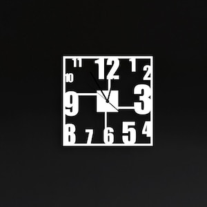 May include: A white clock with black hands on a black wall. The clock is in a living room setting with a grey sofa, a yellow cushion, and a potted plant.