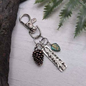 May include: A set of three ceramic mugs with a speckled, matte finish. The mugs are in shades of cream, light gray, and dark gray. Each mug has a simple, minimalist design and a rounded handle.