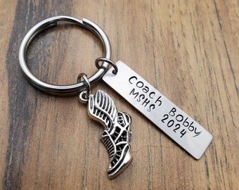 May include: Silver keychain with a running shoe charm and a tag that reads "Coach Bobby MSHS 2024".