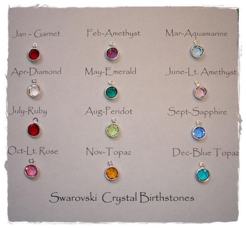 May include: A display of Swarovski crystal birthstone charms. Each charm is a different color, representing a month of the year. The text "Swarovski Crystal Birthstones" is at the bottom.