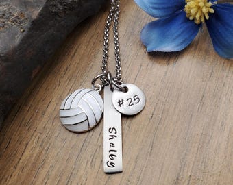 May include: Silver necklace with a volleyball charm, a bar charm with the name "Shelby" engraved on it, and a round charm with the number "#25" engraved on it.