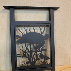 May include: Black metal table leg with a cut-out design of a sea turtle swimming in a coral reef with fish. The leg is rectangular and has a flat top.