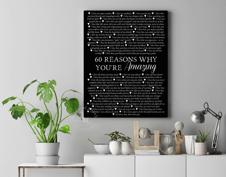 May include: Black and white printable art print with the text "60 Reasons Why You're Amazing" and a list of reasons why someone is amazing. The print is framed and hanging on a wall.