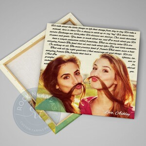May include: A canvas print featuring two women posing with their hair styled as mustaches. The print has a light background with text and the words "Love, Ashley" at the bottom. The canvas is wrapped around a wooden frame.