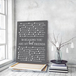 May include: A gray canvas print with white text listing 50 reasons why someone is a best friend. The text includes names, activities, and qualities. The print is framed and hanging on a wall.