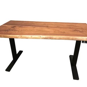 K&ouml;nnte beinhalten: Ein Holzschreibtisch mit einer Live-Edge-Oberfl&auml;che und schwarzen verstellbaren Beinen. Der Schreibtisch hat ein schwarzes Bedienfeld auf der rechten Seite.