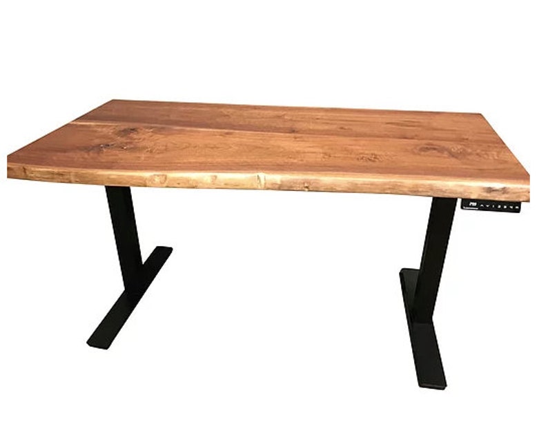 K&ouml;nnte beinhalten: Ein Holzschreibtisch mit einer Live-Edge-Oberfl&auml;che und schwarzen verstellbaren Beinen. Der Schreibtisch hat ein schwarzes Bedienfeld auf der rechten Seite.