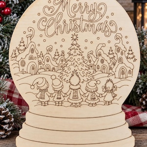 May include: A light-colored wooden snow globe cutout featuring an engraved winter village scene with a central Christmas tree, five children holding hands in the foreground, and the text Merry Christmas at the top of the circular design.
