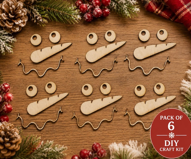 May include: A set of six wooden snowman face craft kits, each containing two circular eyes, one carrot-shaped nose, and one wavy mouth piece. A red circular badge in the corner displays the text PACK OF 6 DIY CRAFT KIT.