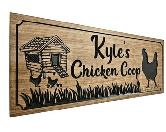Può includere: Un cartello di legno con il testo "Kyle's Chicken Coop" in lettere nere. Il cartello presenta una silhouette nera di un pollaio con una gallina e pulcini davanti.