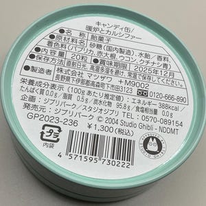 May include: A round, light teal candy tin with Japanese text and a Studio Ghibli logo. The label lists ingredients, nutritional information, and a best-by date of December 2025. The tin contains 20 pieces of candy.
