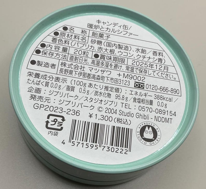 May include: A round, light teal candy tin with Japanese text and a Studio Ghibli logo. The label lists ingredients, nutritional information, and a best-by date of December 2025. The tin contains 20 pieces of candy.