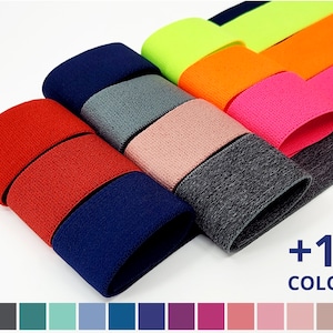 May include: A variety of elastic bands in different colors, including red, navy blue, gray, pink, orange, and neon green. The elastic bands are arranged in a stack, with the top band being neon green. The image also shows a color chart with 13 different colors, including gray, teal, blue, purple, and pink. +13 COLORS