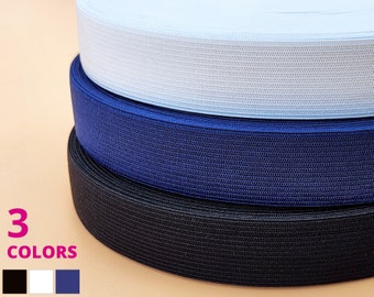 May include: Three rolls of elastic trim in black, navy blue, and white. The elastic is woven with a textured pattern.