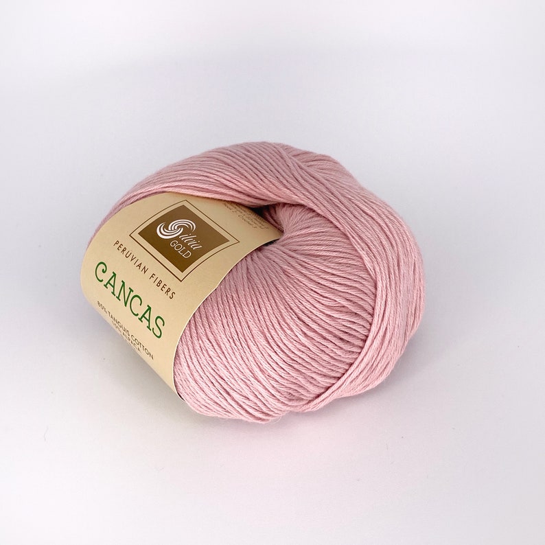 May include: A ball of pink Peruvian Pima cotton yarn labeled "Cancas" by "Silver Gold" Peruvian Fibers. The yarn is 100% Pima cotton.