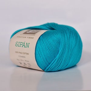 May include: A skein of turquoise blue yarn labeled "Sip&aacute;n" Peruvian Fibers 100% Pima Cotton Combed 50g, 140m, 185yds.