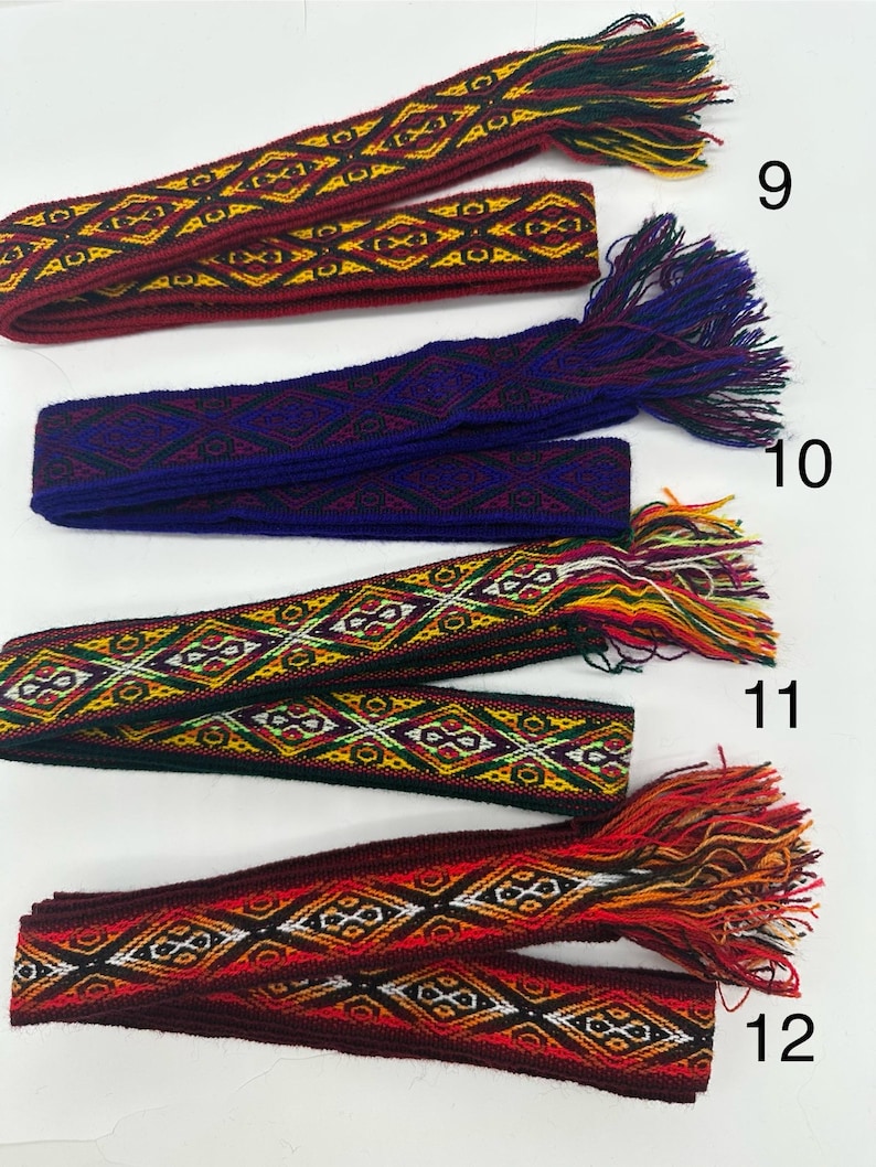 May include: Four woven fabric belts with fringe ends in various colors, including red, blue, yellow, and black. The belts are numbered 9, 10, 11, and 12.