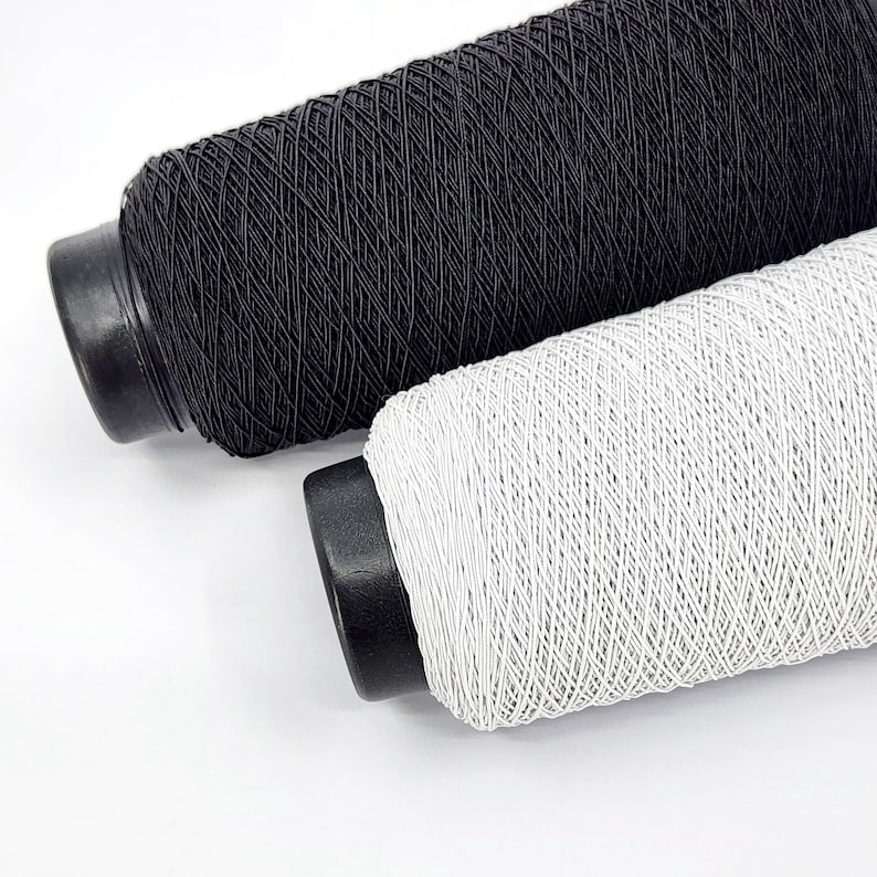 May include: Two spools of thread, one black and one white. The spools are wound with thread and have a black plastic base.