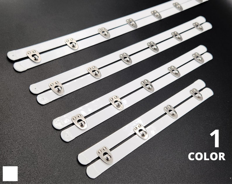 May include: Four white bra strap extenders with silver metal hooks and eyes. 1 COLOR.