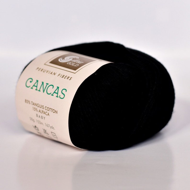 May include: A skein of black yarn labeled "CANCAS" with the text "PERUVIAN FIBERS" and "85% TANGUIS COTTON 15% ALPACA BABY 30g 153m 167yds."