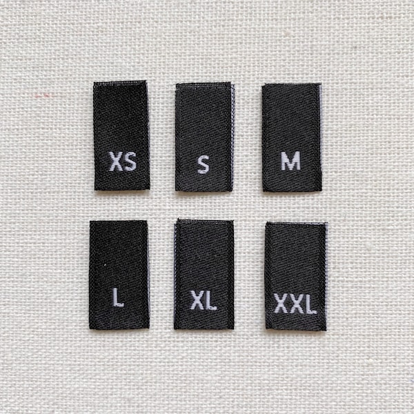 Etiquetas de tamaño tejidas - Negras con letras blancas Tallas XS-XXL / Etiquetas de tamaño plegadas Dimensiones totales 1 3/4" x 1/2" / Etiquetas de tamaño para prendas de vestir