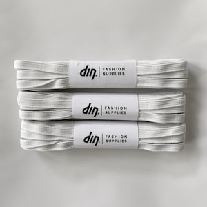 May include: Three white elastic bands with the text "din. FASHION SUPPLIES" printed on each label.