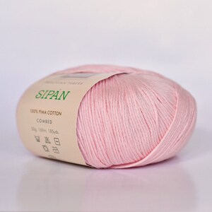 May include: A pink ball of yarn labeled "SIPAN 100% PIMA COTTON COMBED 50g 169m. 185yds."