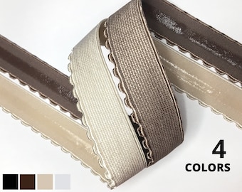 May include: Four colours of elastic trim with a scalloped edge. The trim is available in black, brown, beige, and white.