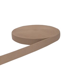 May include: A roll of beige elastic band, ideal for sewing projects.