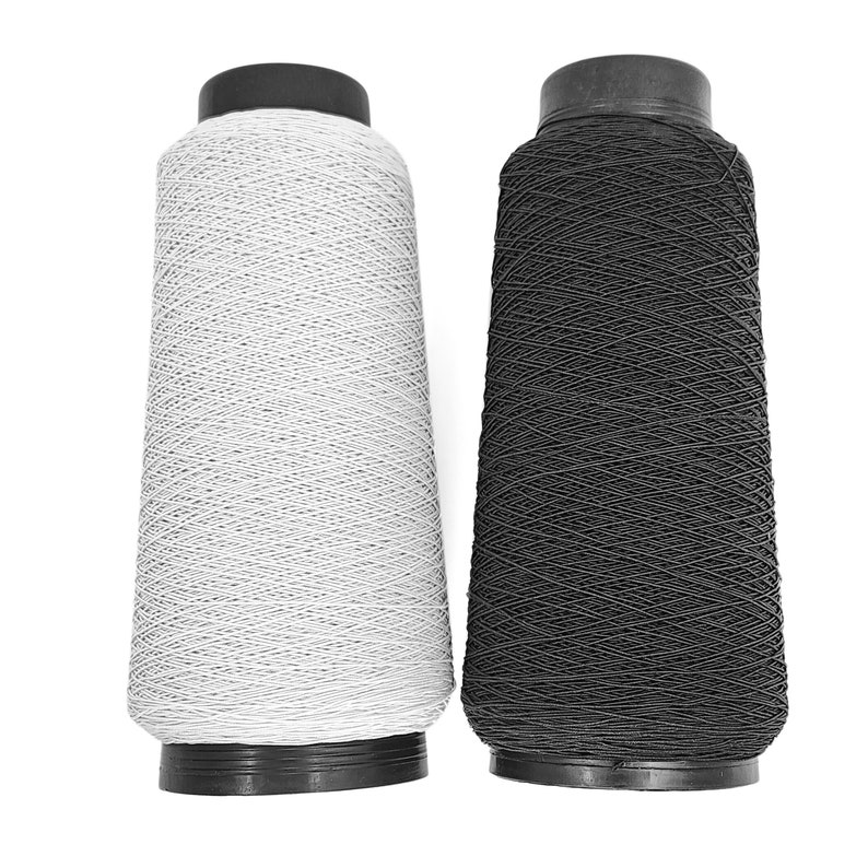 May include: Two spools of thread, one white and one black, are shown against a white background. The spools are made of plastic and have a black top.