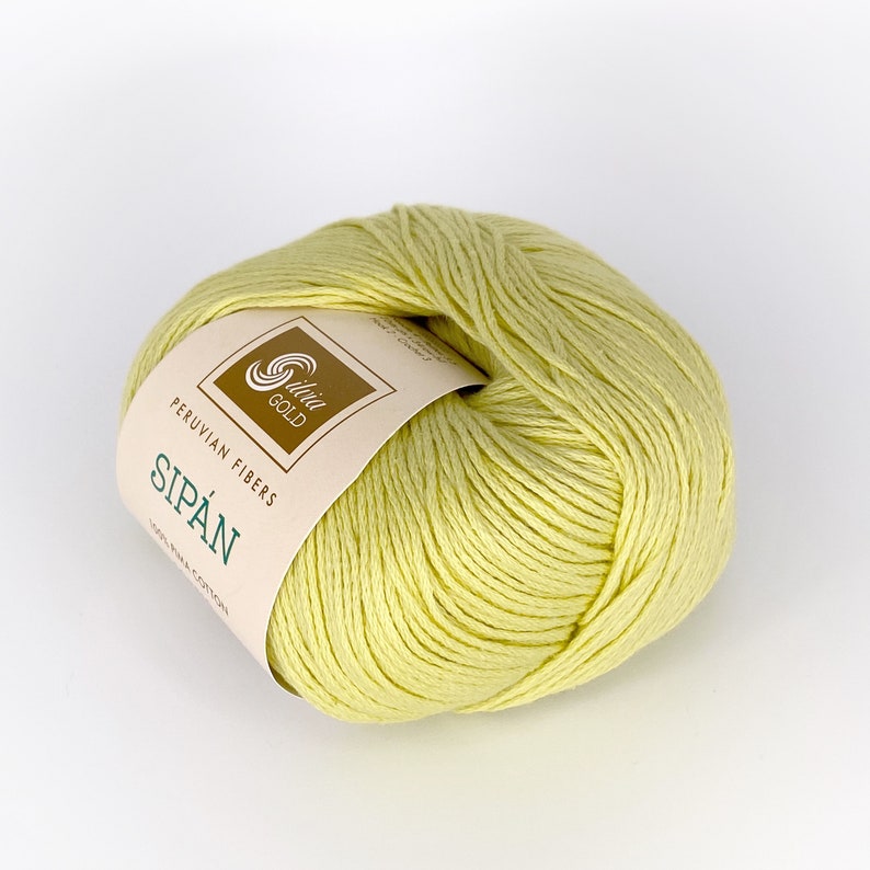 May include: A ball of pale yellow yarn with a label that reads "Peruvian Fibers Sip&aacute;n 100% Pima Cotton" and a logo that says "Slivia Gold".