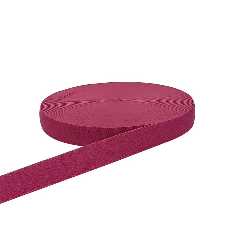 May include: A roll of burgundy elastic band, a type of fabric used for sewing and crafting.