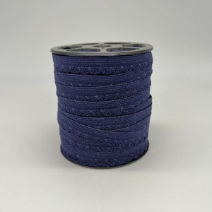 May include: A spool of navy blue elastic trim with a decorative scalloped edge.