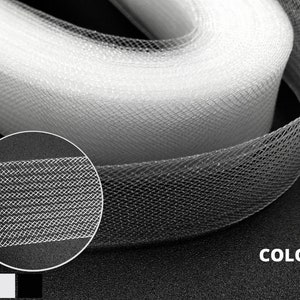 May include: White tulle ribbon with a fine mesh texture. The ribbon is rolled up and shows the delicate pattern of the fabric. 3 Colors.