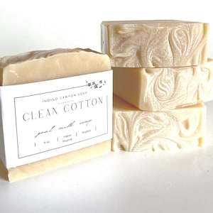 May include: Four bars of white goat milk soap with a swirl pattern. The soap is labeled "Indigo Canyon Soap Clean Cotton goat milk soap 6 oz Hand Poured Virginia".