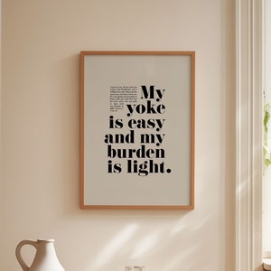 May include: A framed print with a beige background and black text that reads "My yoke is easy and my burden is light."