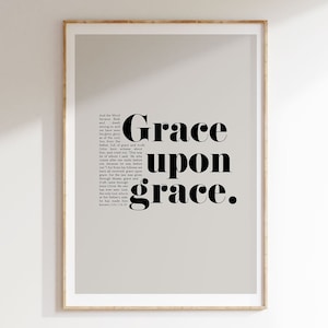 May include: A printable wall art design with a gray background and black text that reads "Grace upon grace." The text is from the Bible, John 1:16-17.