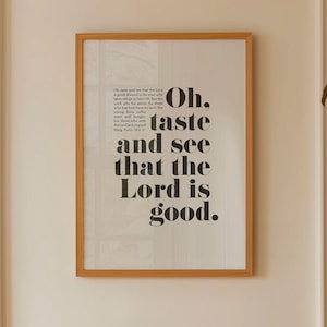 Könnte beinhalten: Ein gerahmter Druck mit den Worten "Oh, schmeckt und seht, dass der HERR gütig ist" in fetter schwarzer Schrift. Der Druck befindet sich in einem hellbraunen Holzrahmen und hängt an einer weißen Wand. Der Druck enthält auch einen Bibelvers.