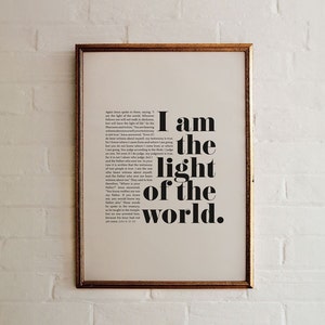 K&ouml;nnte beinhalten: Ein gerahmter Druck mit wei&szlig;em Hintergrund und schwarzem Text. Der Text lautet "Ich bin das Licht der Welt."