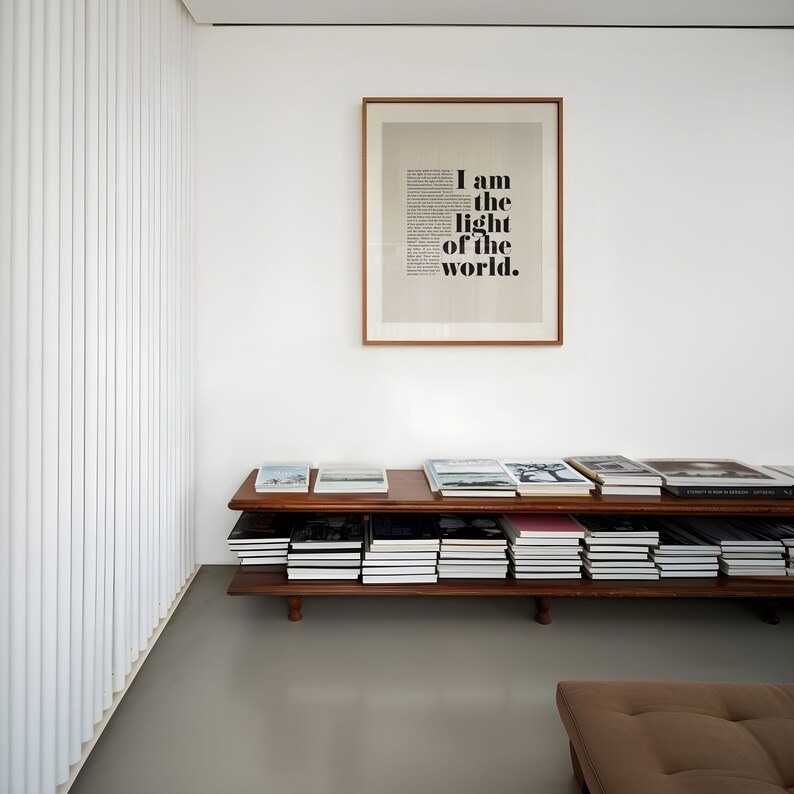 K&ouml;nnte beinhalten: Ein B&uuml;cherregal aus Holz mit zwei Regalbrettern, gef&uuml;llt mit B&uuml;chern. Das Regal steht an einer wei&szlig;en Wand mit einem gerahmten Druck, auf dem "Ich bin das Licht der Welt" steht.
