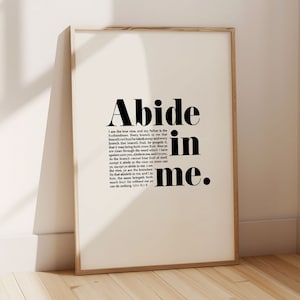 Op de afbeelding: Zwart-wit typografieprint met de woorden "Abide in me." De print bevat een Bijbelvers uit Johannes 15:4-5.