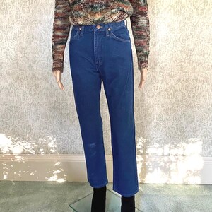 May include: A pair of blue denim jeans with a high waist and straight legs.