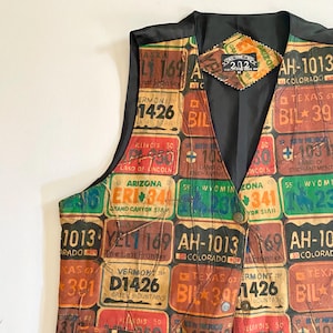 May include: A vintage vest featuring a patchwork design of license plates from various states. The vest has a black satin lining and a diamond-shaped tag near the collar. The license plates are in various colors and sizes.