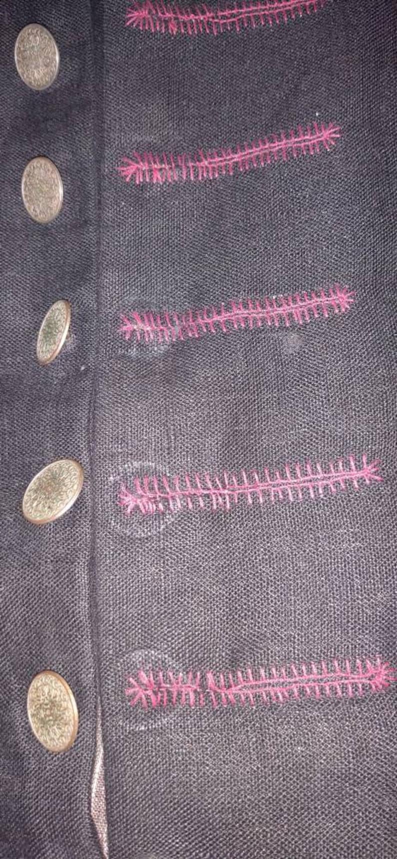 May include: Black fabric with pink stitching. The fabric has a series of decorative stitches in a zig-zag pattern.