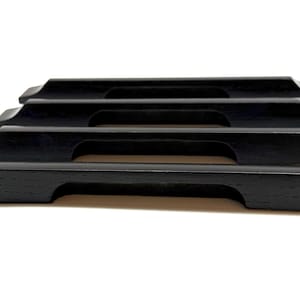May include: Four black wooden cabinet pulls with a rectangular shape and a curved handle cutout. The pulls are arranged in a horizontal stack, showcasing their design and finish. The hardware is suitable for drawers or cabinets.
